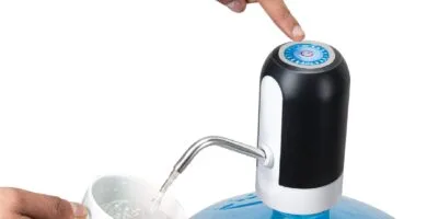 a hand pouring water into a water pump